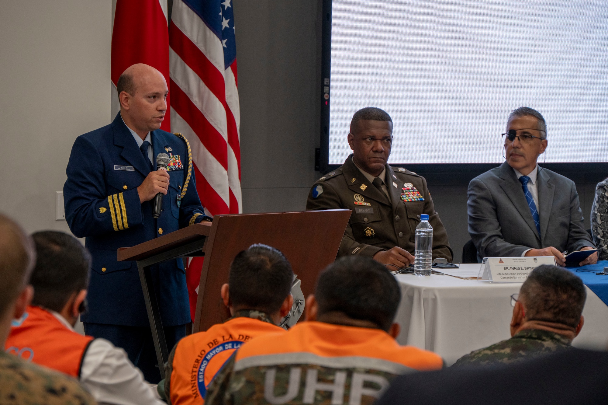 A photo of a man speaking to a group of people.