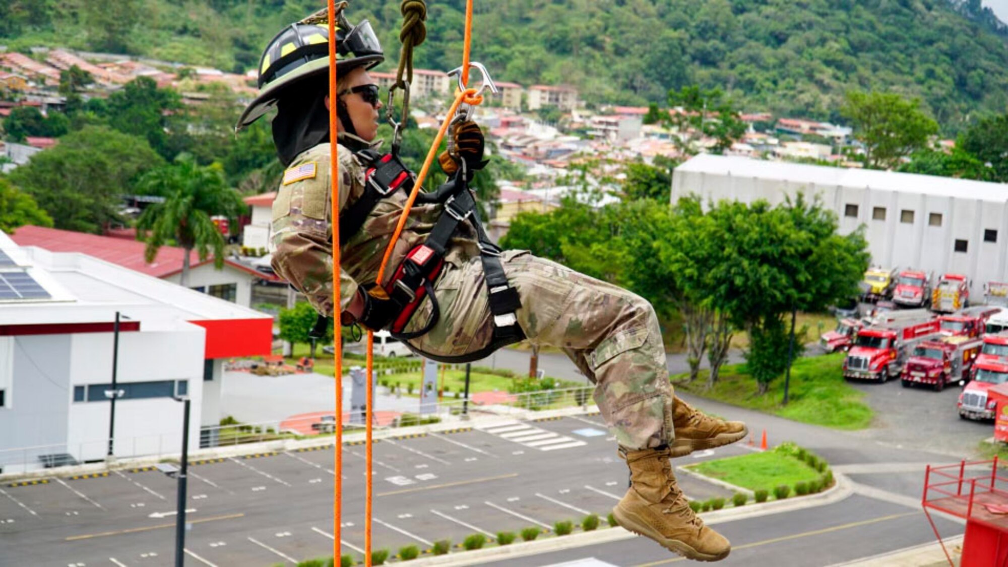 A photo of a firefighter in a repelling system.