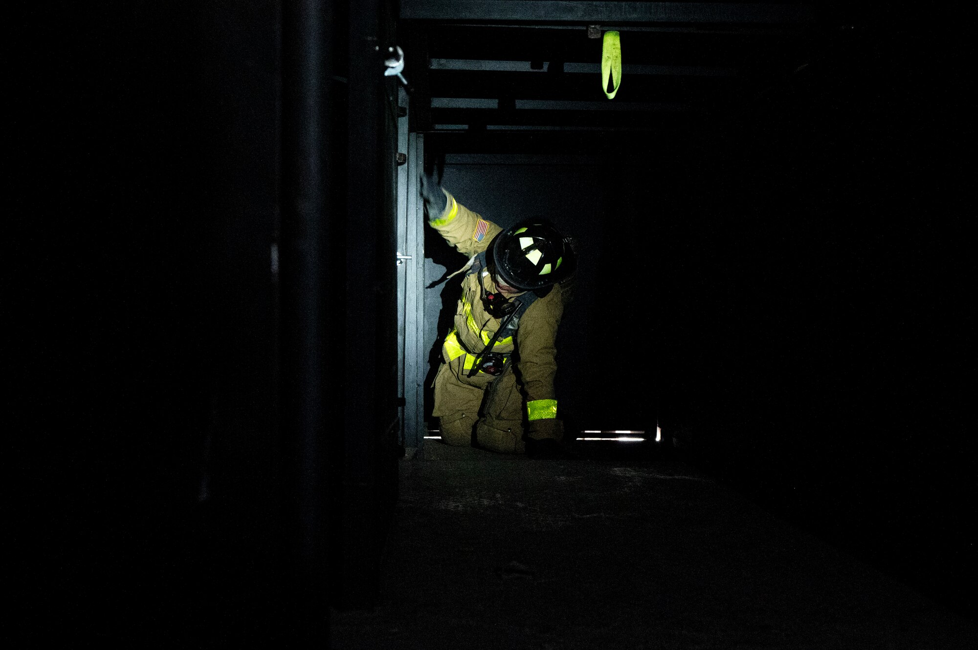 A photo of a firefighter feeling his way in the dark.