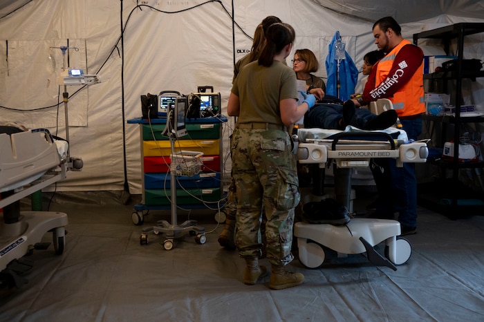 A photo of people standing over a gurney as a simulate patient lies there.