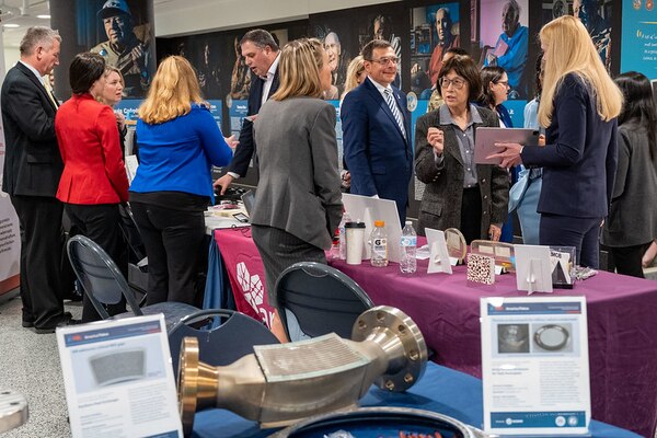 People stand around display tables.