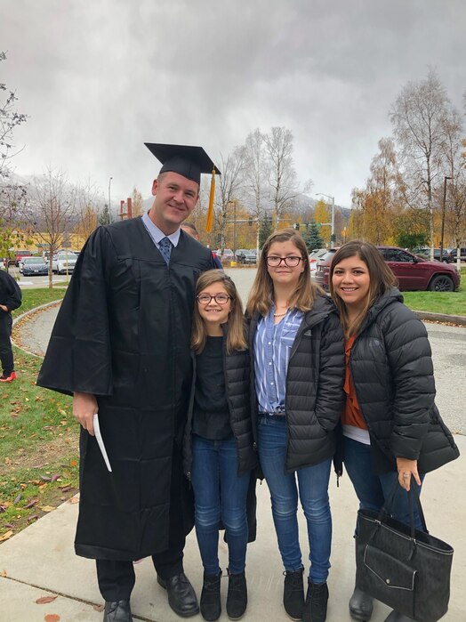  U.S. Air Force Master Sgt. Thomas Hallanger stands with his family and poses for a photo.