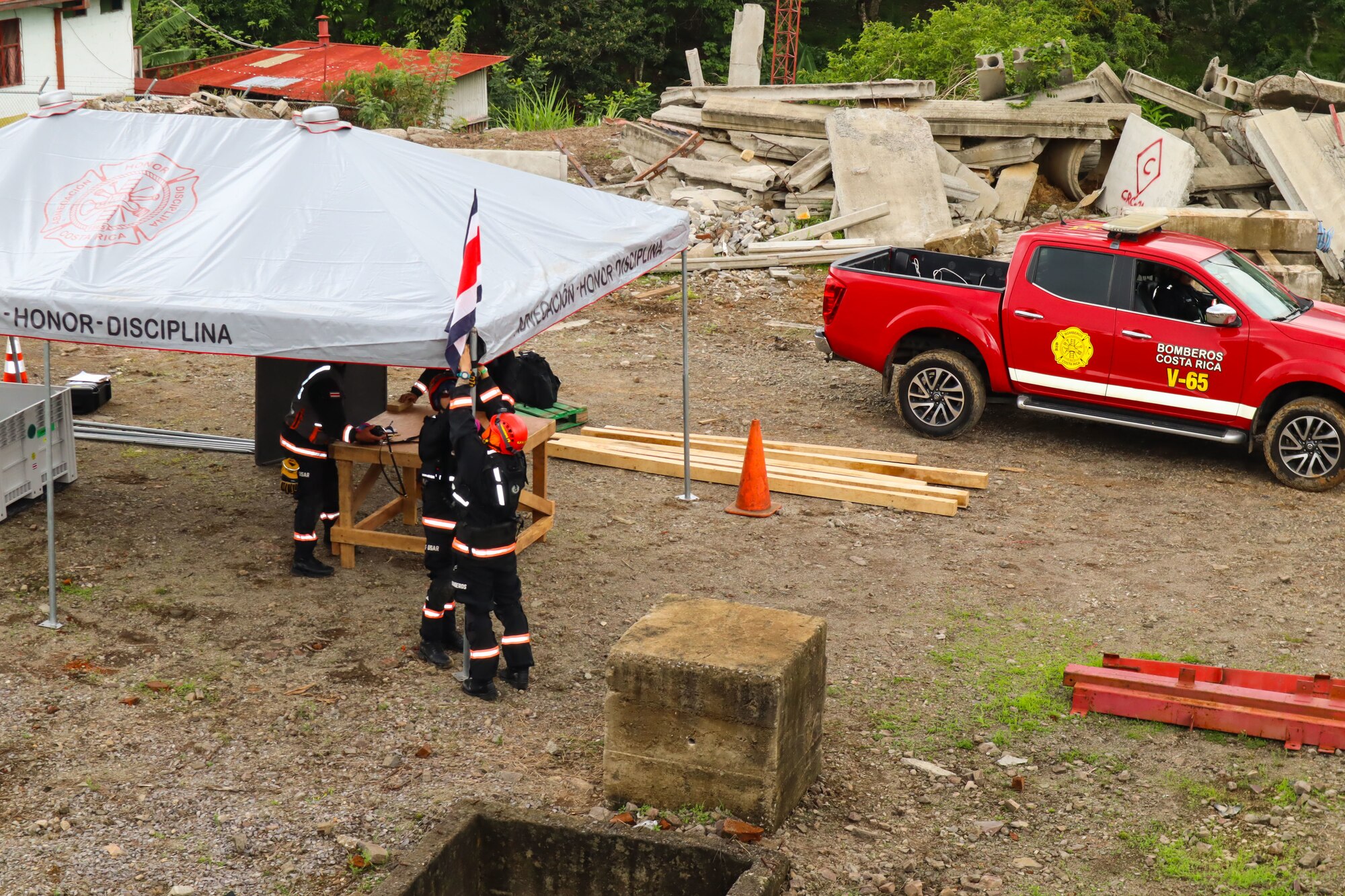 A photo of firefighters hanging a flag.