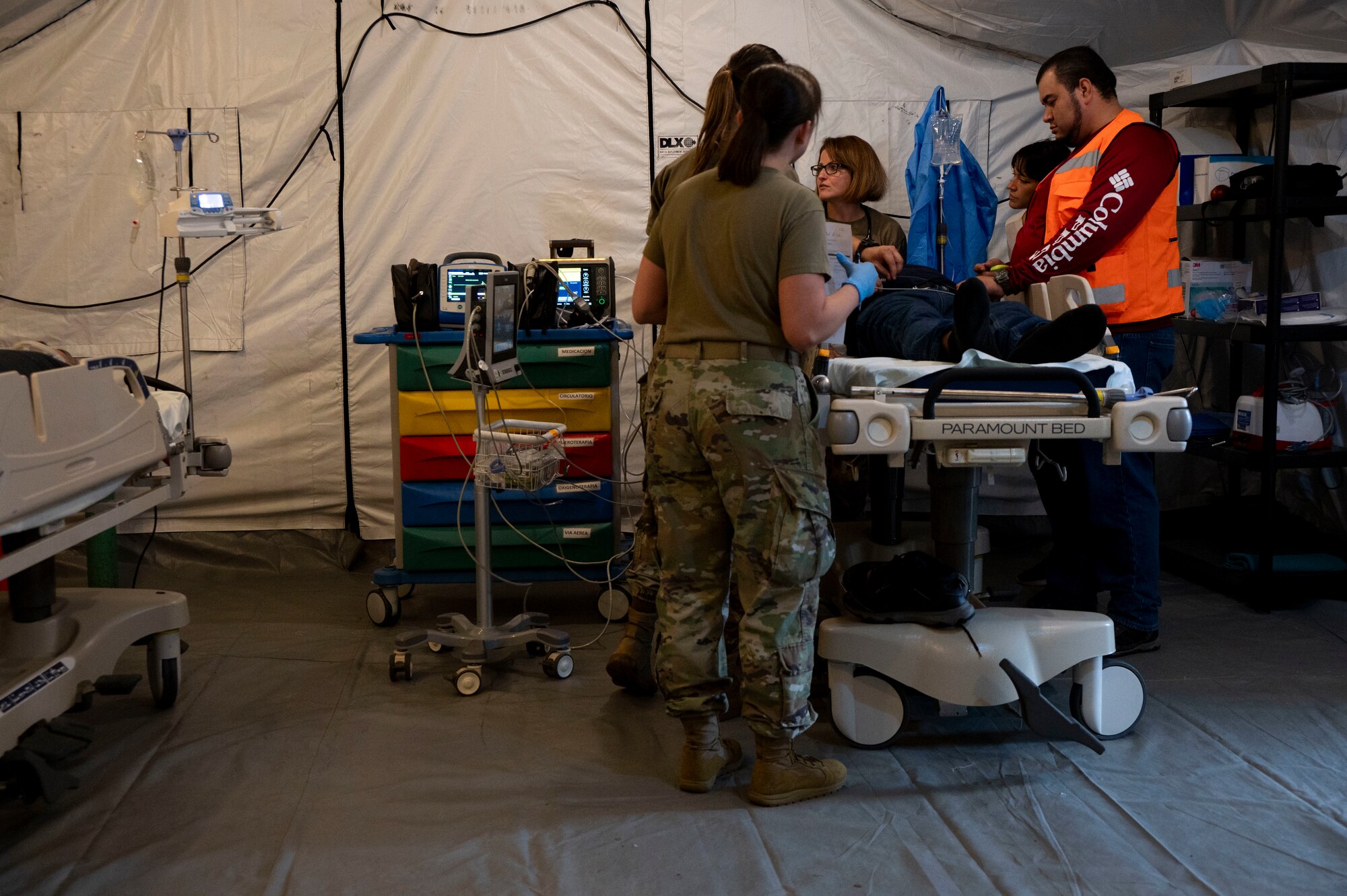 A photo of people standing over a gurney as a simulate patient lies there.