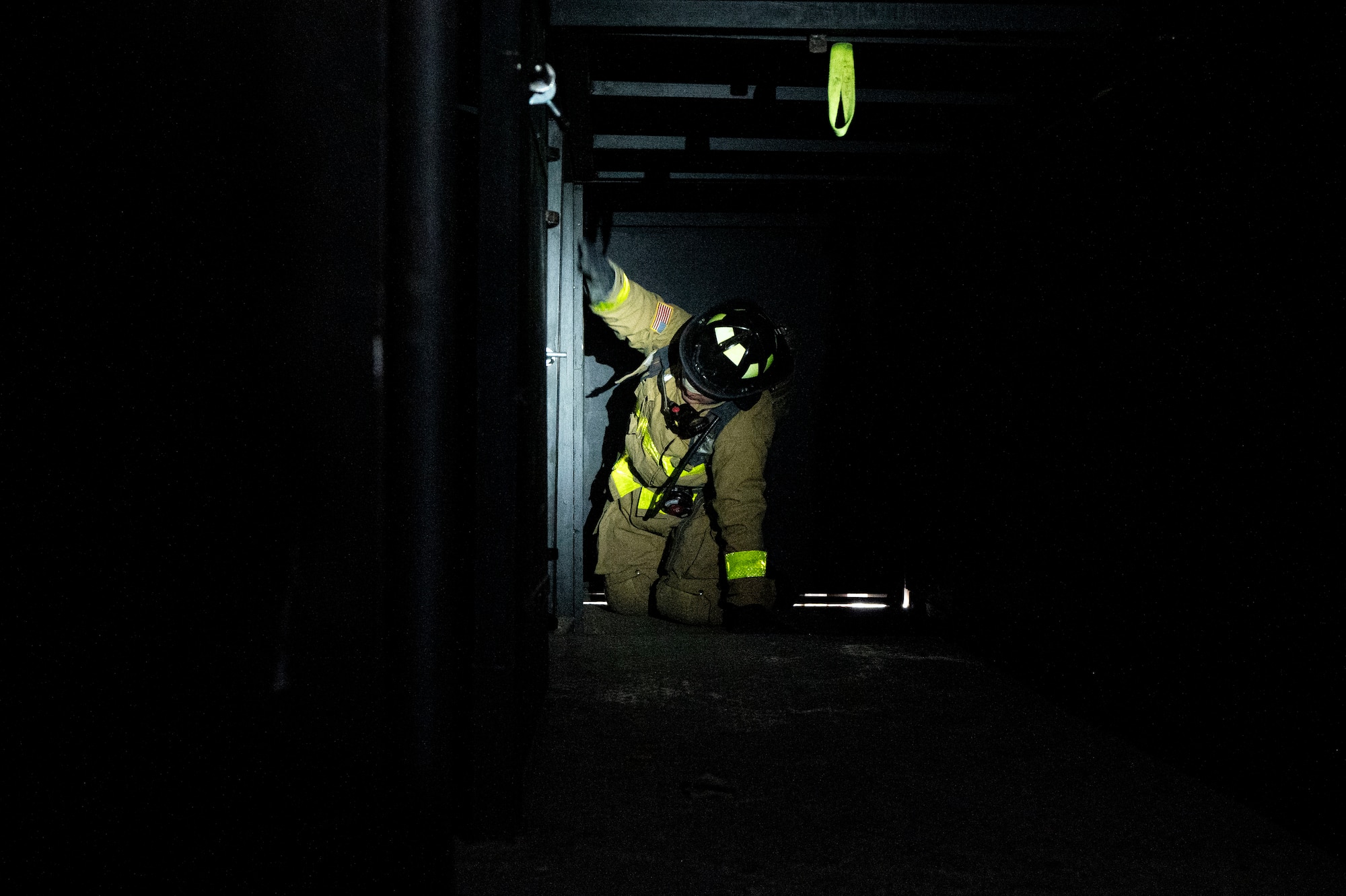 A photo of a firefighter feeling his way in the dark.