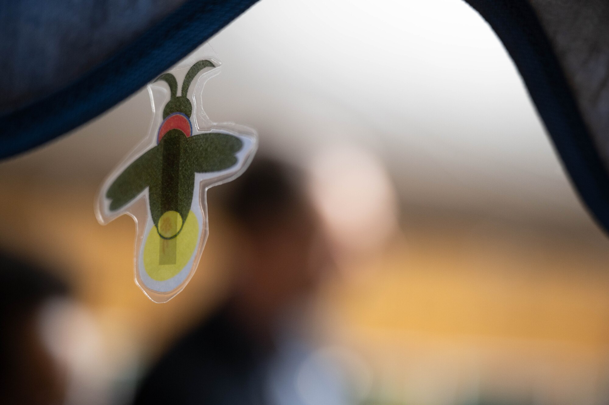 A firefly decoration dangles on a stand.
