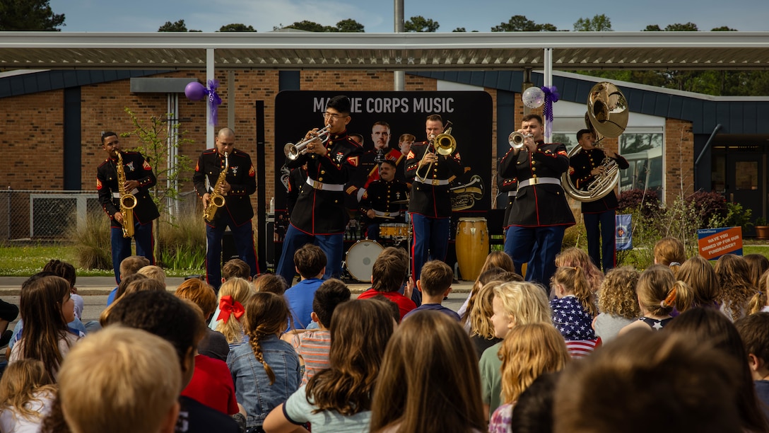 U.S. Marines with 2d Marine Division (MARDIV) Band perform in front of students during a static display held at Swansboro Elementary School in Swansboro, North Carolina, April 17, 2024. 2d Battalion, 2d Marine Regiment, 2d MARDIV hosted the display for the annual Month of the Military Child Celebration to foster community relations, while being role models for Onslow County Schools students. (U.S. Marine Corps photo by Pfc. Micah Thompson)