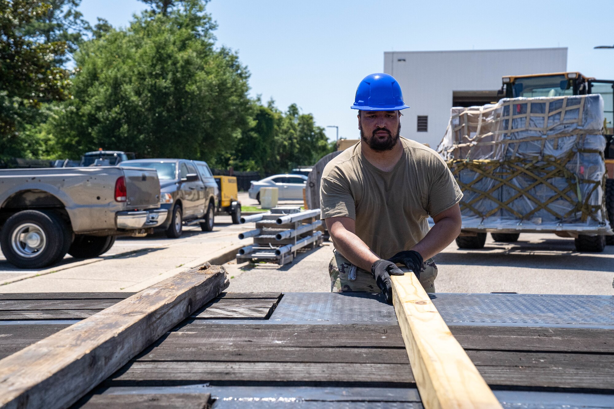 U.S. Air Force Staff Sgt. Javier Calvo, 85th Engineering Installation Squadron cable antennae technician, places wood on a flatbed truck at the 85th EIS, Mississippi, May 20, 2024.