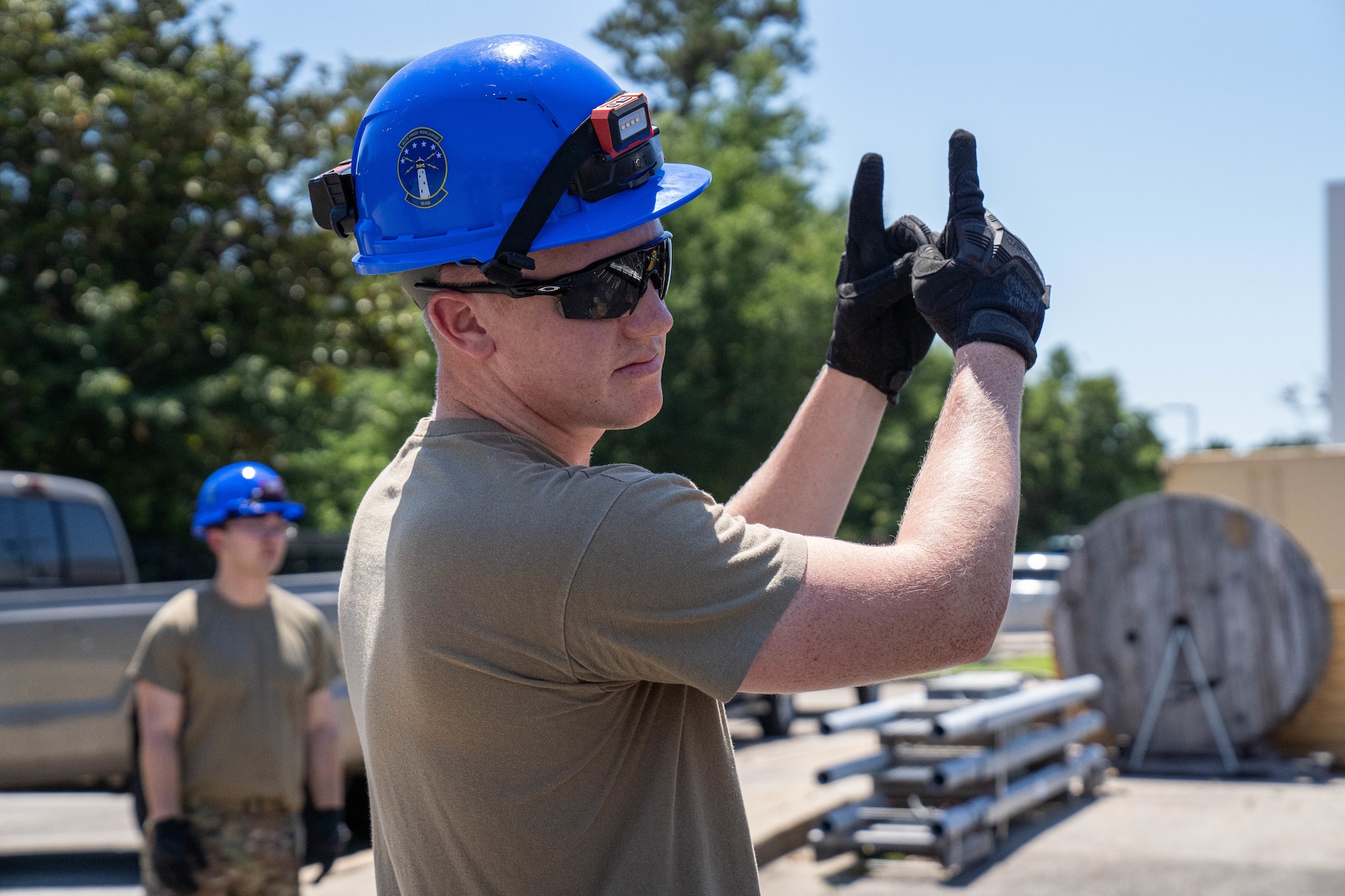 U.S. Air Force Staff Sgt. Collin Swiger, 85th Engineering Installation Squadron radar, airfield and weather systems specialist supervisor, gives hand signals at the 85th EIS, Mississippi, May 20, 2024.