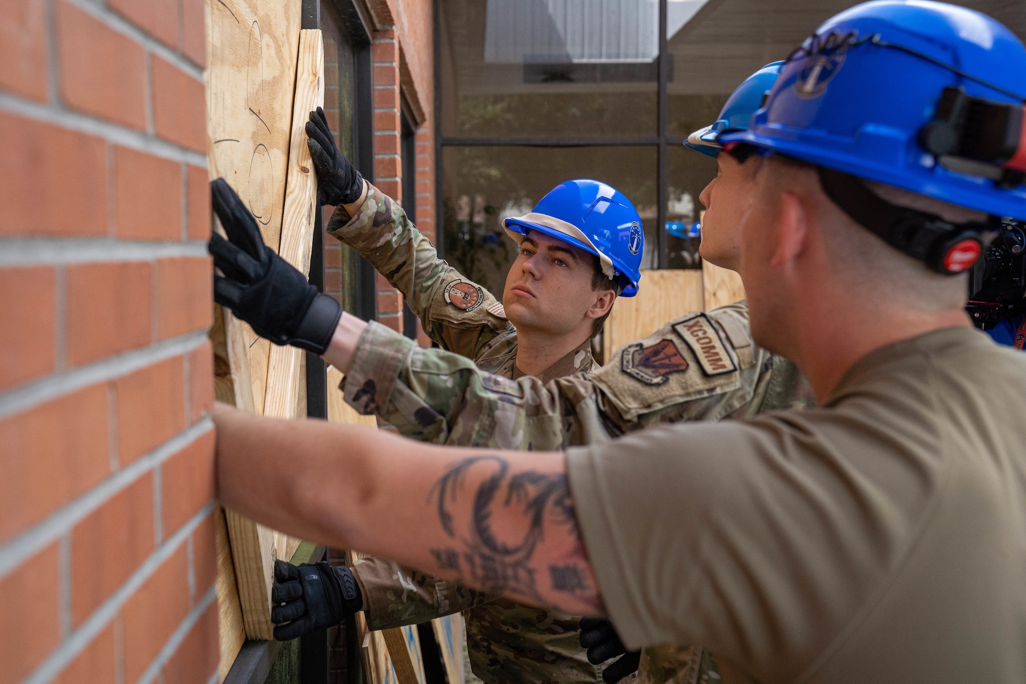 U.S. Airmen assigned to the 85th Engineering Installation Squadron place wood panels on a window for facility hardening during the natural disaster exercise at the 85th EIS, Mississippi, May 21, 2024.