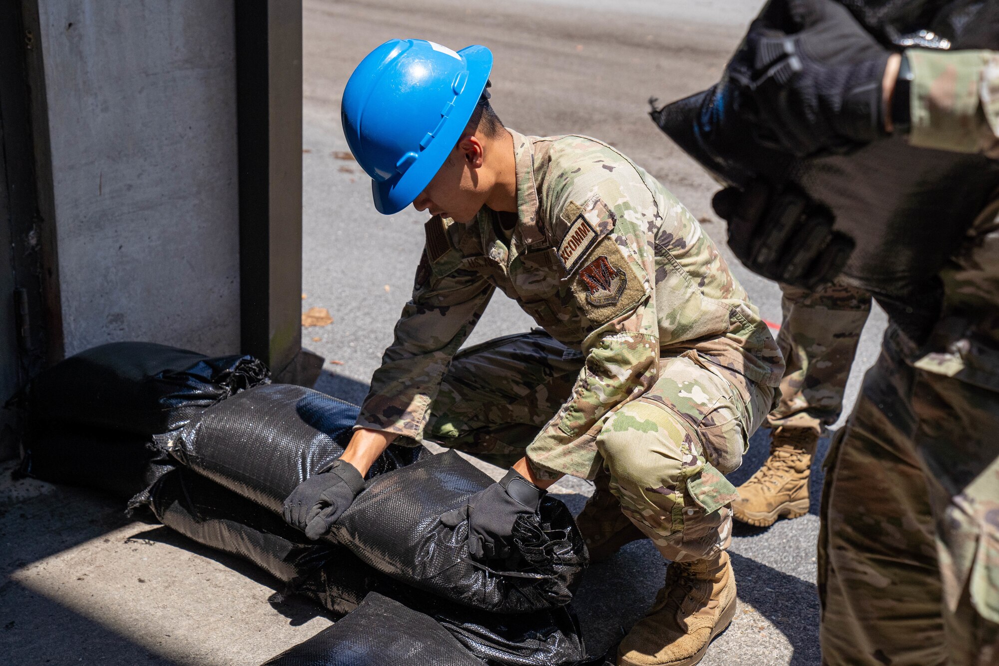 U.S. Air Force 2nd Lt. Anhtu Ho, 85th Engineering Installation Squadron cyberspace engineer, places sandbags against a door for facility hardening at the 85th EIS, Mississippi, May 21, 2024.