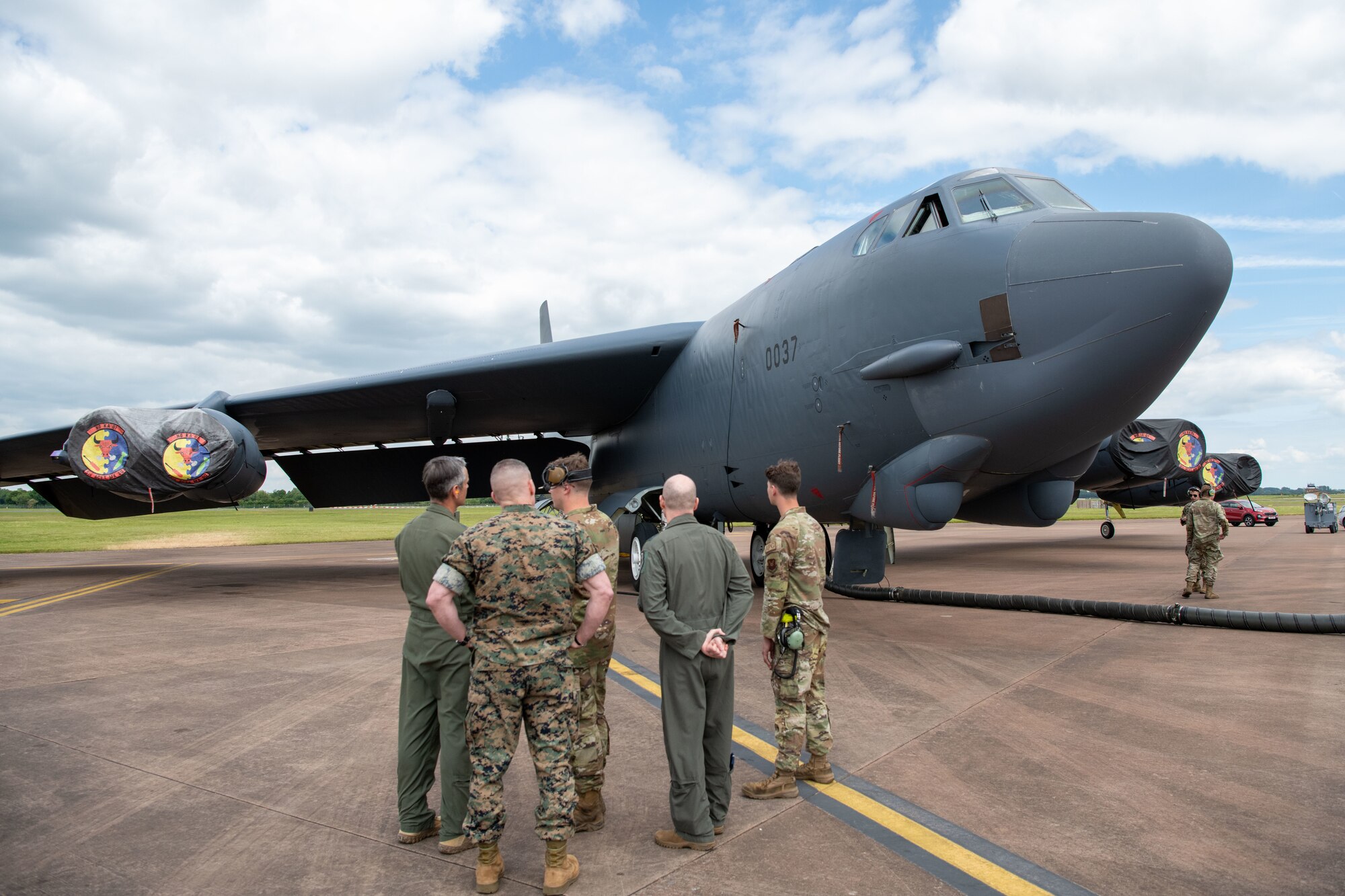Airmen stand in front of a B-52