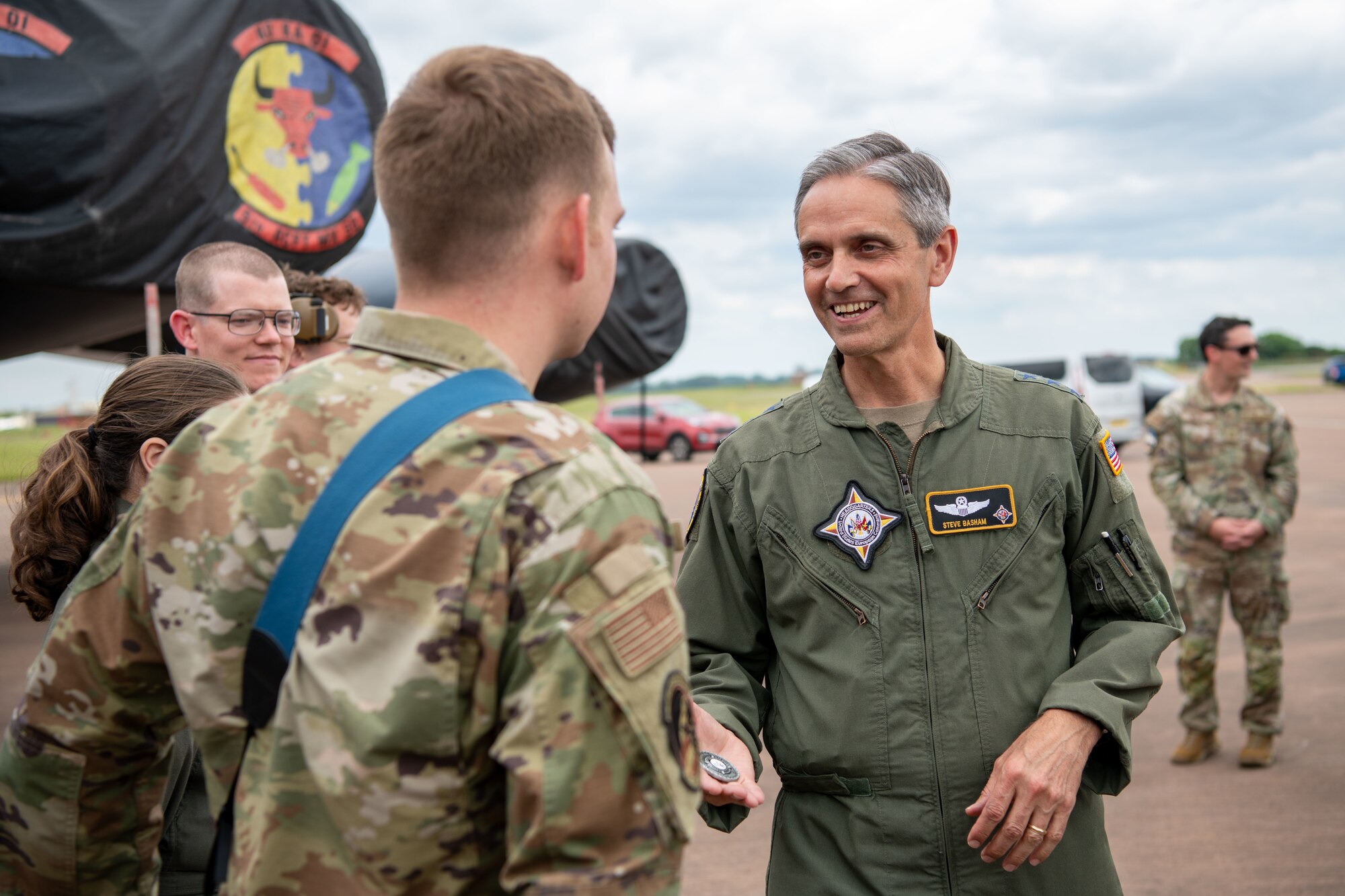 Airman prepares to shake hands while holding a coin