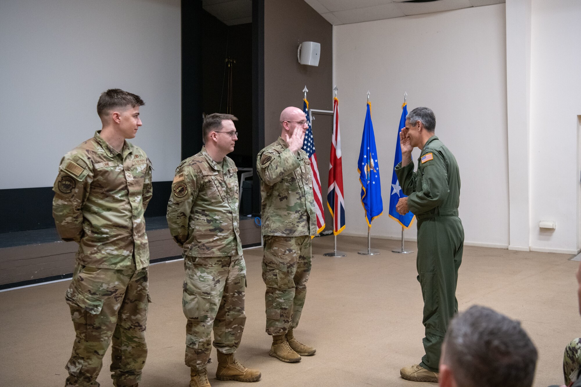 Airmen salute each other while being recognized