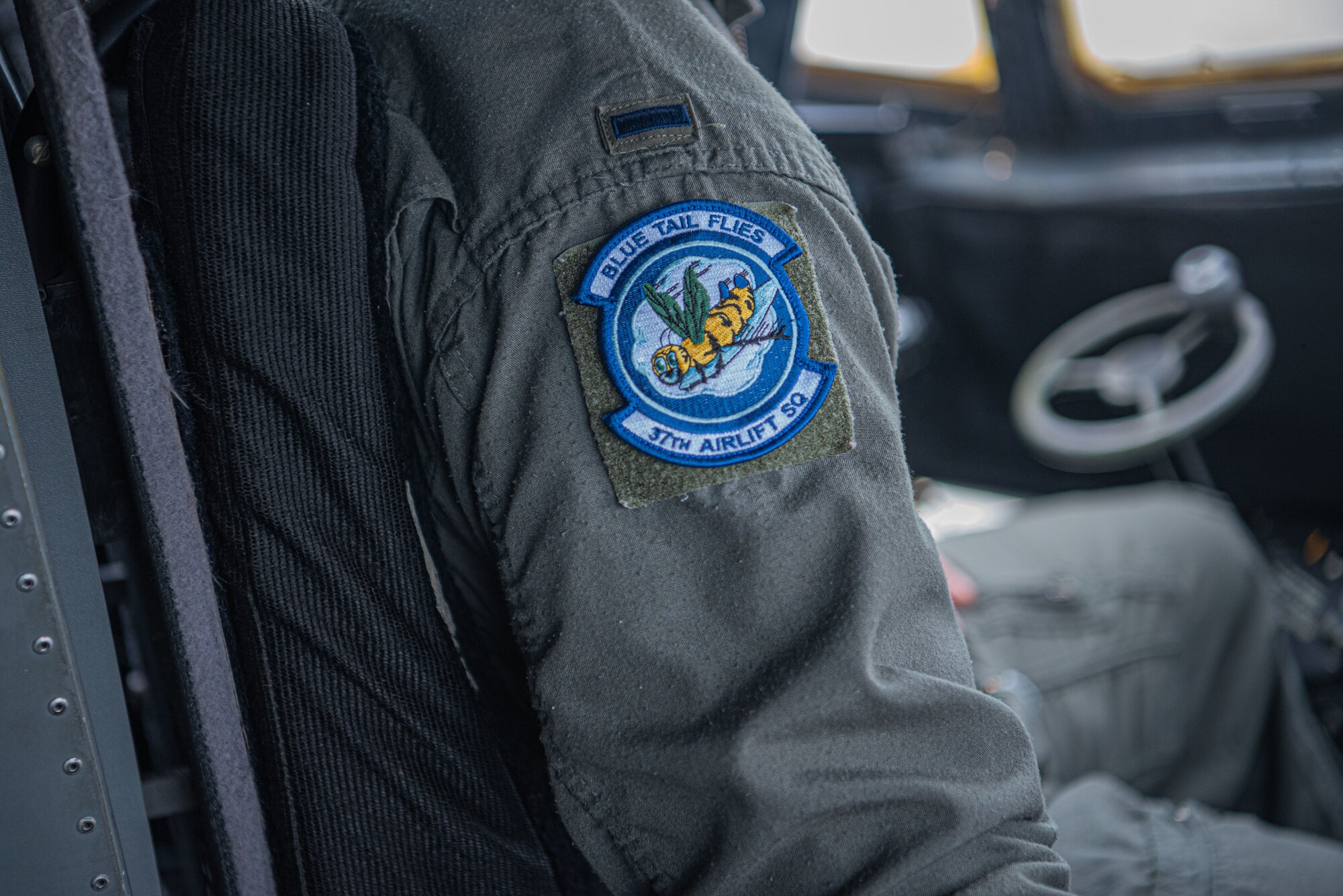 A person sits with squadron patch on arm