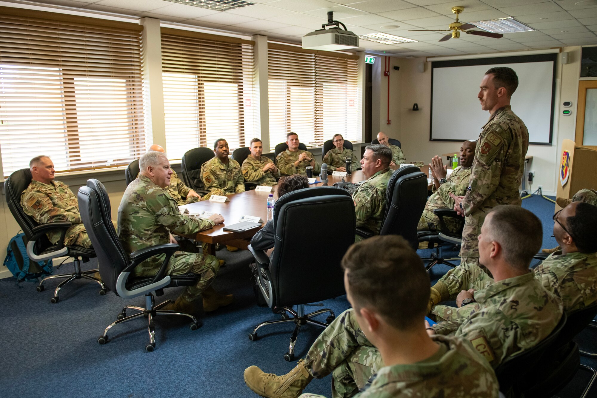 Airman briefs room full of people