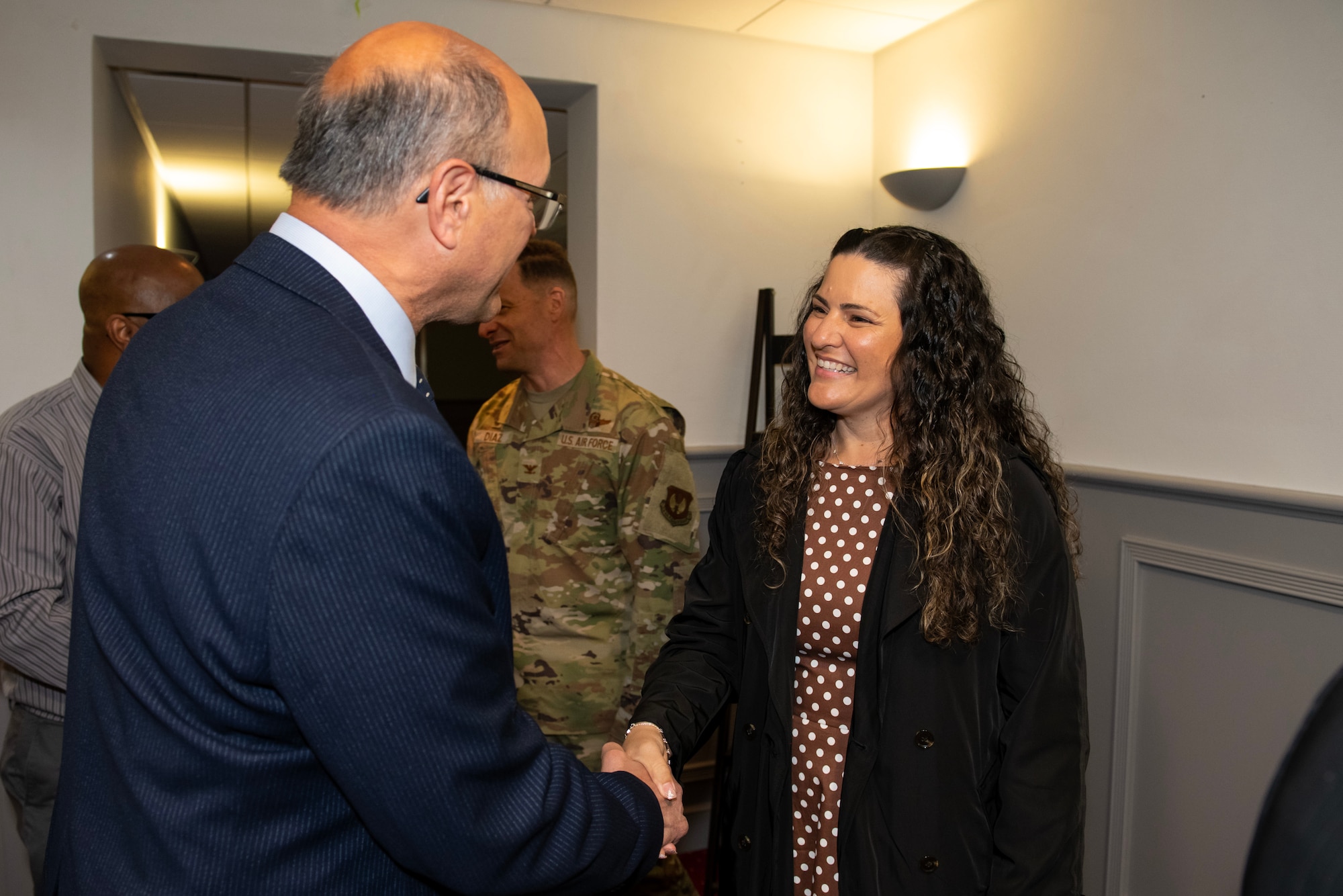 Thomas Krenik, left, 420th Air Base Squadron deputy director, greets the Diaz family after an assumption of command ceremony
