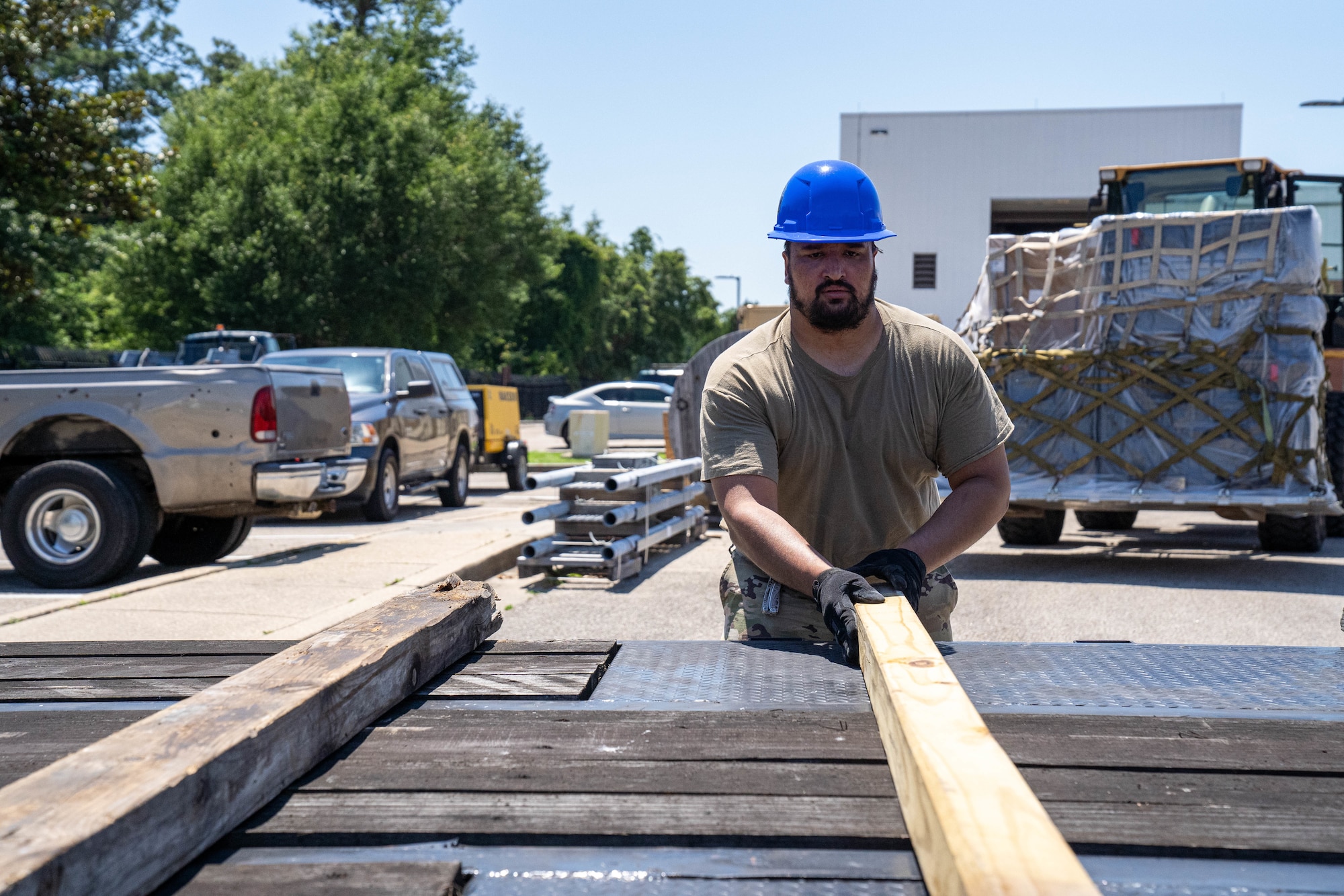 U.S. Air Force Staff Sgt. Javier Calvo, 85th Engineering Installation Squadron cable antennae technician, places wood on a flatbed truck at the 85th EIS, Mississippi, May 20, 2024.