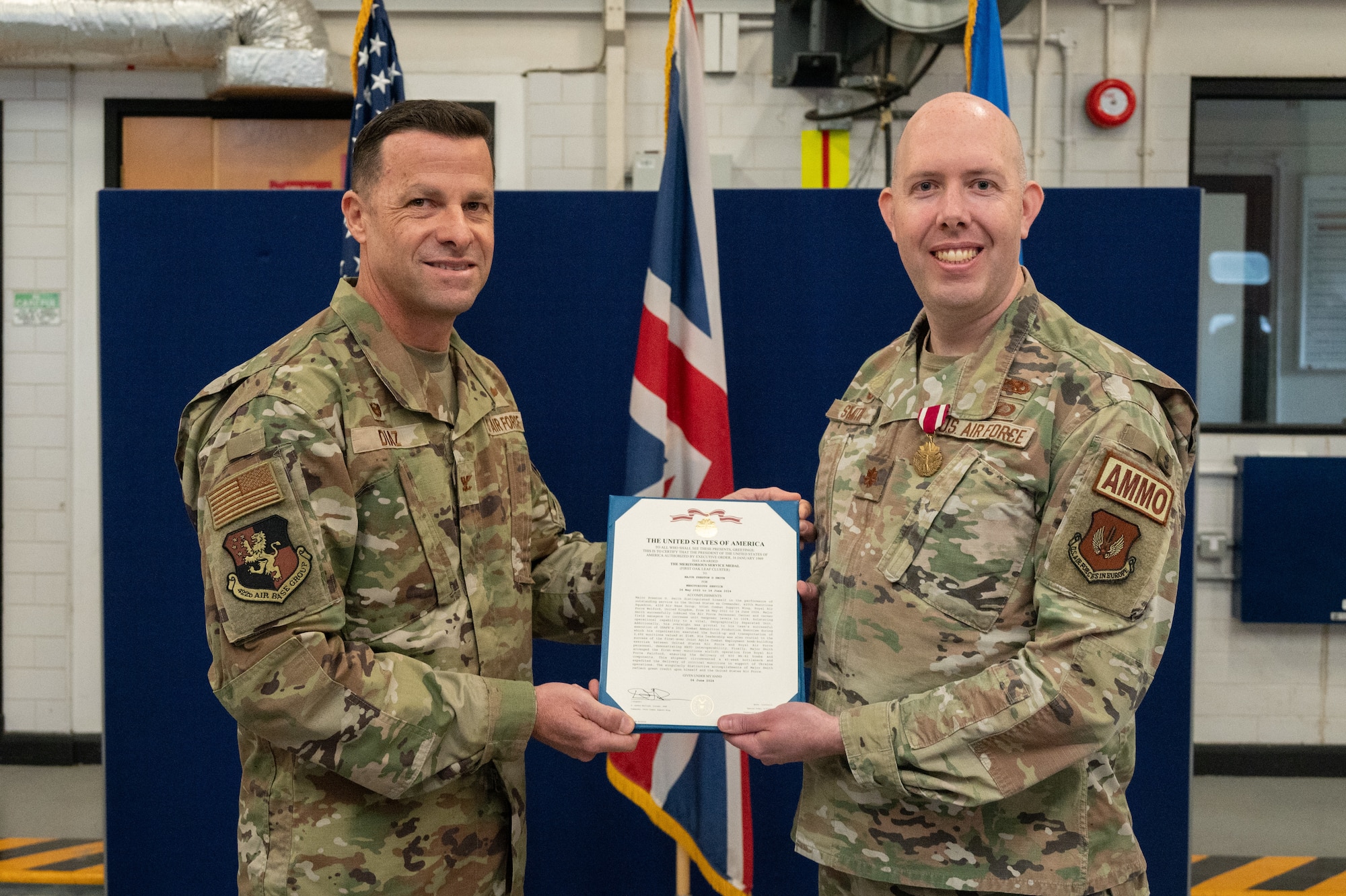 U.S. Air Force Col. Ricardo M. Diaz, left, 422nd Air Base Group commander, presents a meritorious service medal to Maj. Preston G. Smith, right, 420th Munitions Squadron outgoing commander, during a change of command ceremony
