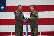 Two men in uniform hold a certificate.