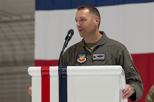 A man in uniform stands behind a podium.