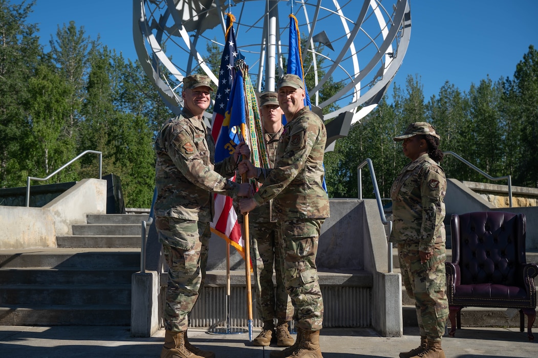 U.S. Air Force Col. Paul Townsend, 354th Fighter Wing commander, left, receives the 354th's guidon from outgoing Command Chief, Chief Master Sgt. Sean Milligan during a Command Chief Change of Responsibility at Eielson Air Force Base, Alaska, June 7, 2024.