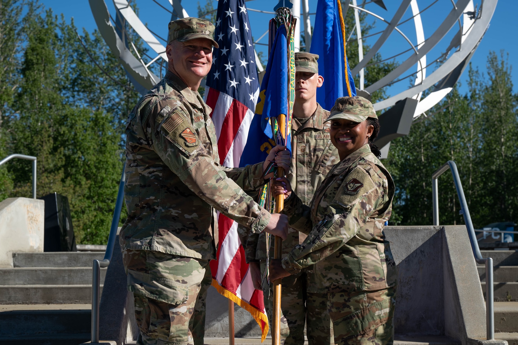U.S. Air Force Chief Master Sgt. Sheronica Blandburg, incoming 354th Fighter Wing command chief, receives the wing's guidon from Col. Paul Townsend, 354th FW commander, during the Command Chief Change of Responsibility ceremony at Eielson Air Force Base, Alaska, June 7, 2024.
