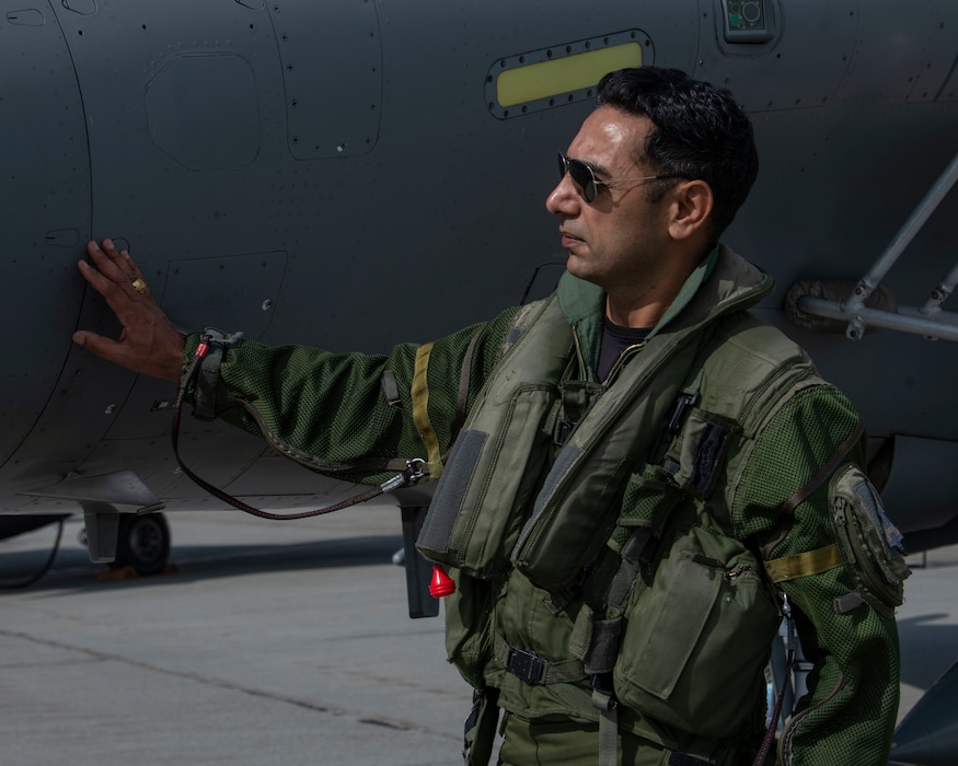 A pilot for the Indian Air Force places his hand on the side of a Rafale aircraft during a pre-flight inspection check.