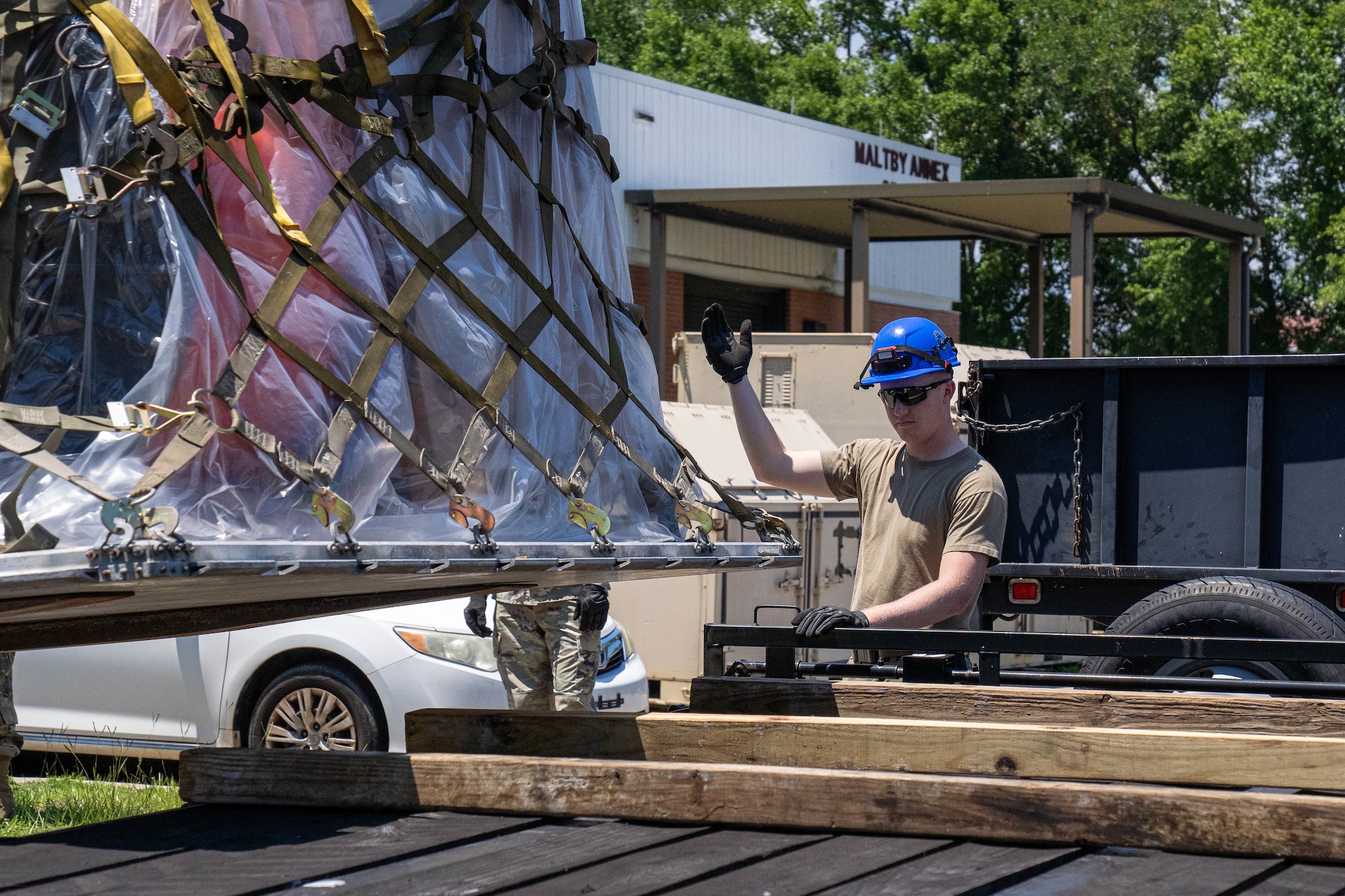 U.S. Air Force Staff Sgt. Collin Swiger, 85th Engineering Installation Squadron radar, airfield and weather systems specialist supervisor, guides a forklift placing a palette on a flatbed truck at the 85th EIS, Mississippi, May 20, 2024.