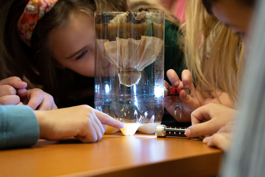 Kids participate in a hands-on experiment to understand how wetlands filter water and provide flood and erosion control in a session conducted by the Regulatory Division.
