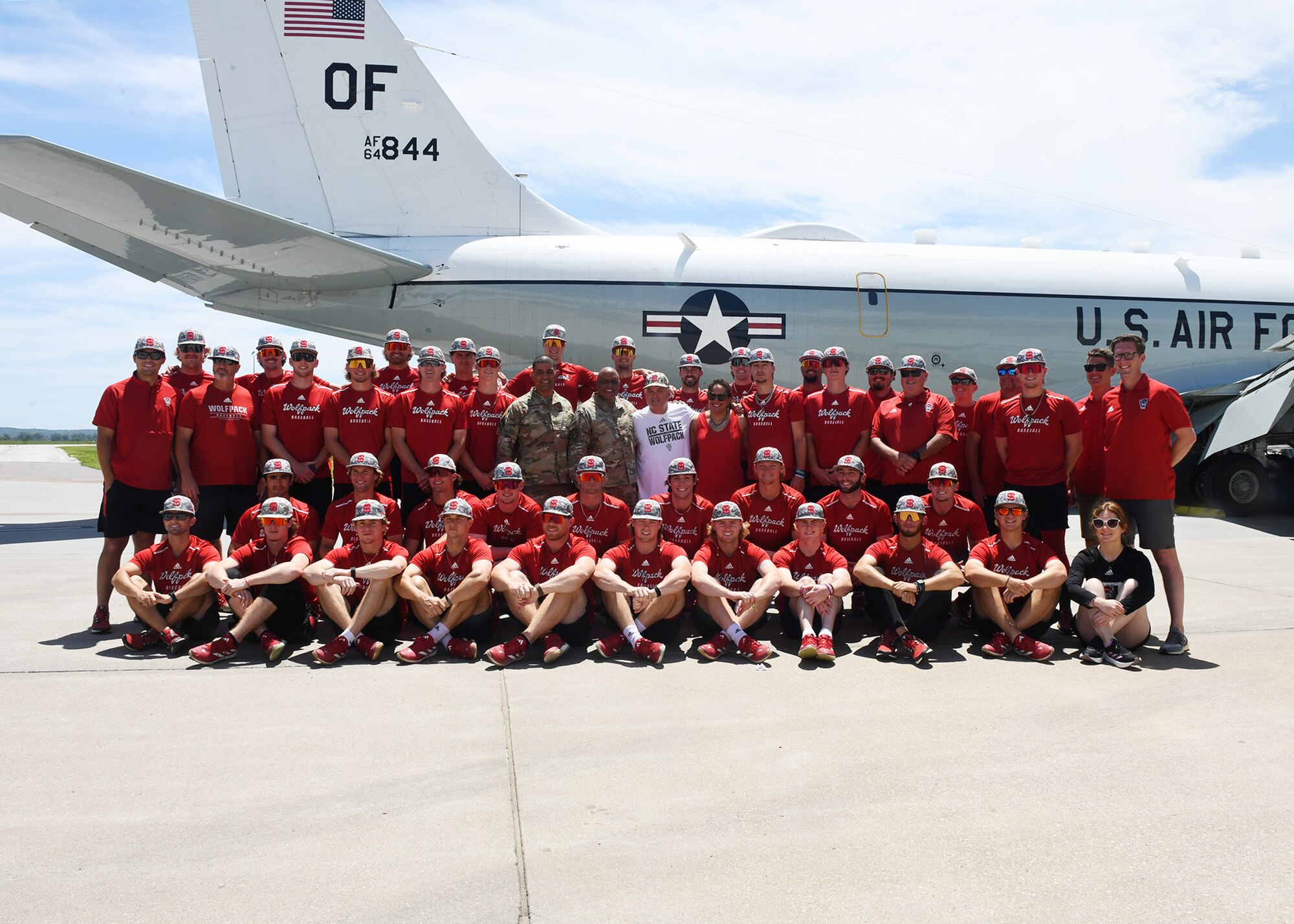 NC State baseball team poses for a group photo in front of a RC-135 Rivet Joint aircraft.
