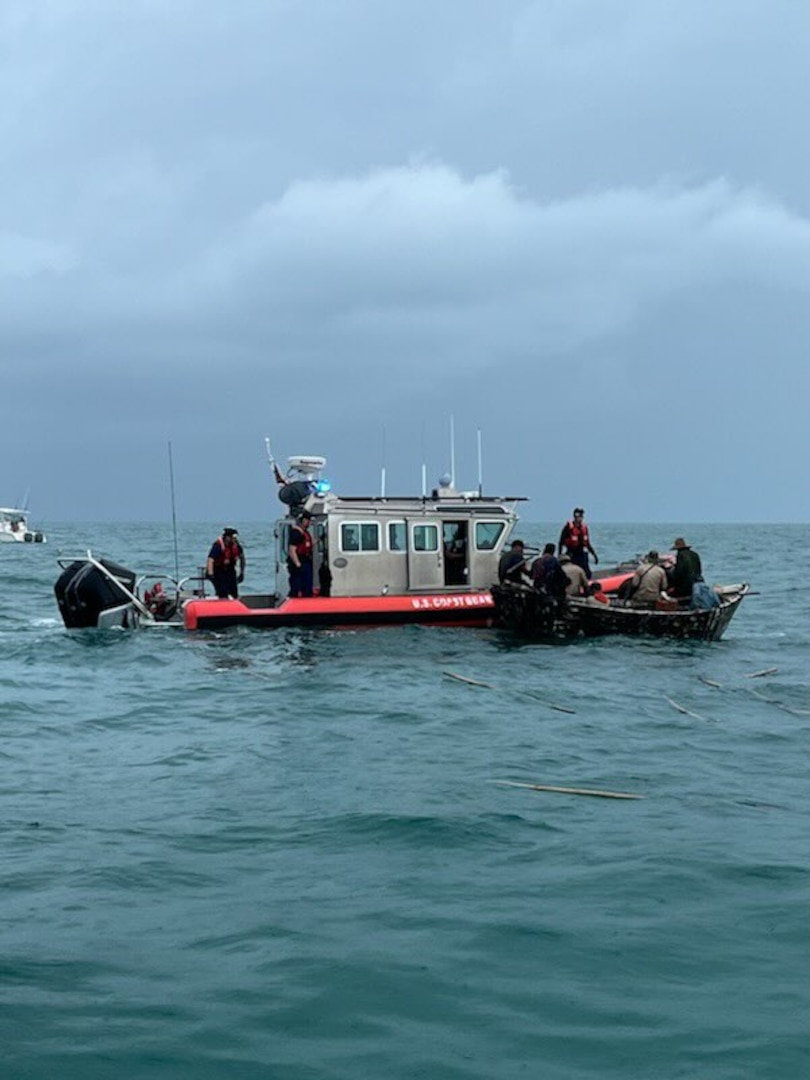 A Coast Guard small boat alongside a Cuban migrant vessel.