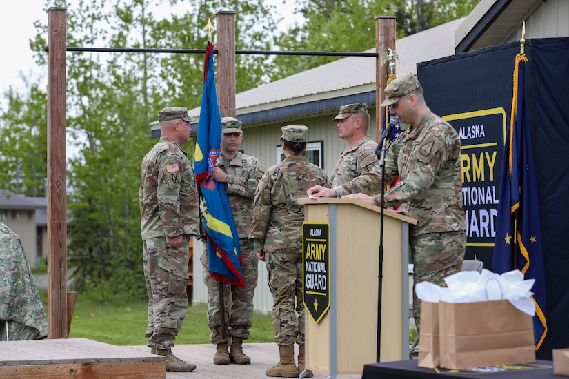 Lt. Col. Chad Ausel, outgoing commander of the Recruiting and Retention Battalion, Alaska Army National Guard, holds the battalion colors for the final time during a change of command ceremony held at Camp Carroll on Joint Base Elmendorf-Richardson, Alaska, May 31, 2024.