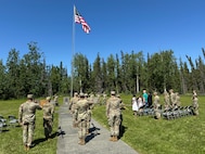 Alaska Army National Guardsmen, friends, and family gather at Camp Carroll flagpole to watch the 207th Multi-Functional Training Regiment change of command ceremony on Joint Base Elmendorf-Richardson, Alaska, June 16, 2024.