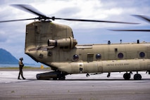 U.S. Army Sgt. Cade Eastwood, a flight engineer with Bravo Company, 3rd Battalion, 25th Aviation Regiment, General Support Aviation Brigade, inspects a CH-47 Chinook in preparation for an external lift operations exercise at Marine Corps Air Station Kaneohe Bay, Marine Corps Base Hawaii, June 6, 2024. Marines and Soldiers collaborated in an external lift operations exercise, bolstering efficiency in airlifting oversized cargo while offering a distinctive cross-training opportunity. (U.S. Marine Corps photo by Lance Cpl. Carlos Daniel Chavez-Flores)