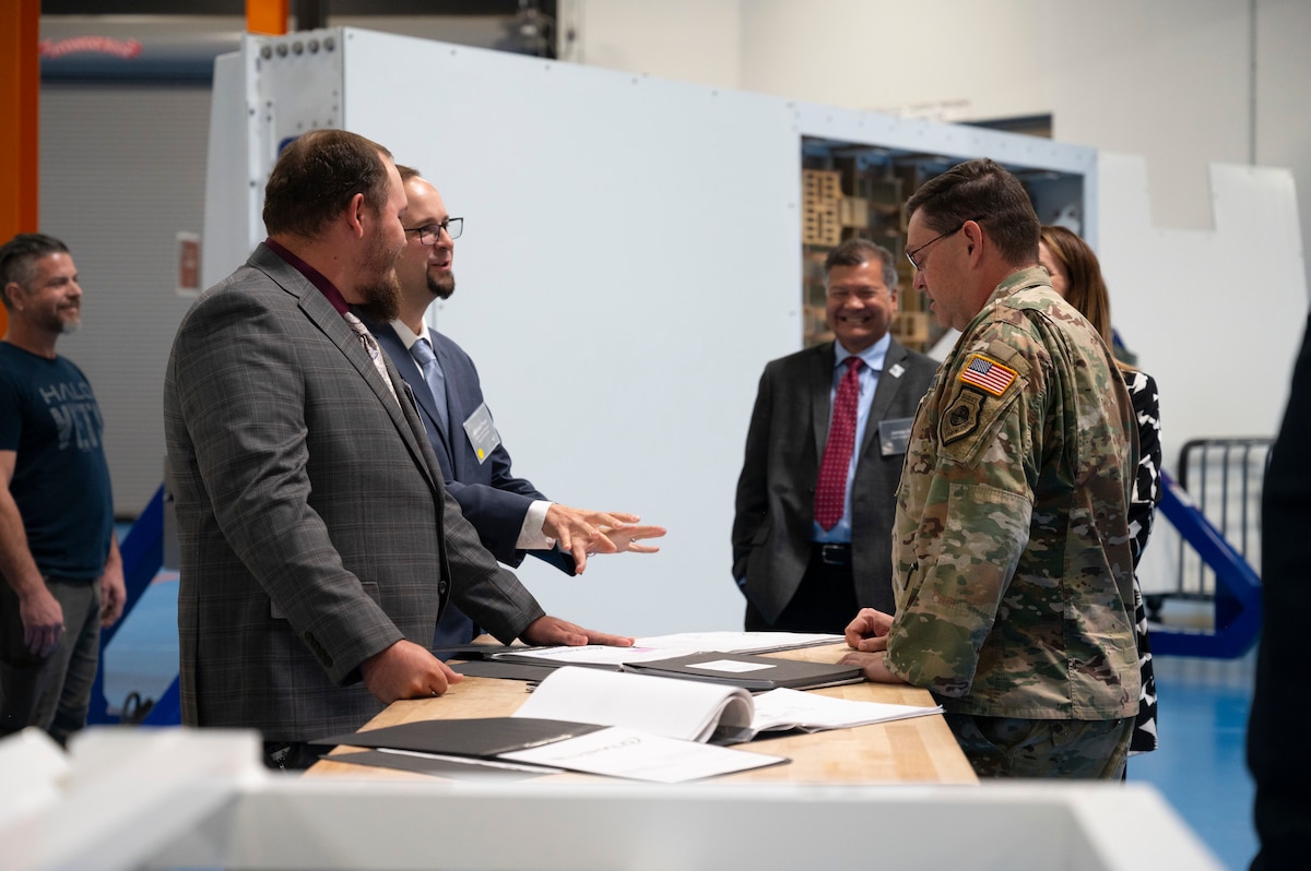 Man talks with other men about documents.