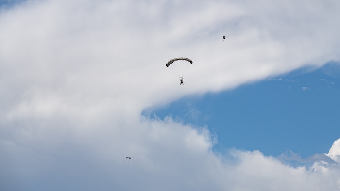 Three paratroopers descending from the sky.