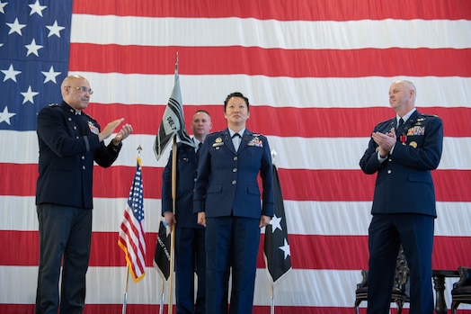  Lt. Gen. David N. Miller, Jr, Space Operations Command commander, left, and Col. Brett T. Swigert, right, clap after Col. Phoenix L. Hauser, center, officially took command of Space Delta 7 - Intelligence, Surveillance and Reconnaissance during a change of command ceremony.