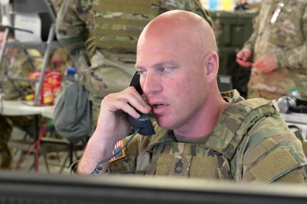 Indiana National Guard Sgt. 1st Class Cole Skillman, a 38th Infantry Division battle noncommissioned officer, answers a phone call during the division's Warfighter Exercise 24-4 at Camp Atterbury near Edinburgh, Indiana, June 15, 2024. Warfighter exercises evaluate Soldier proficiencies as they respond, communicate and develop plans and actions to virtual battlefield scenarios.