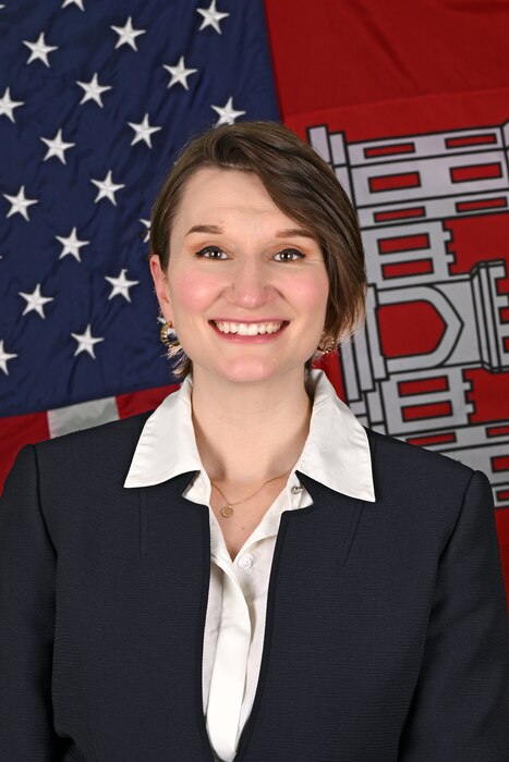 A man and sits for an official photo in front of the U.S. Flag and U.S. Army Corps of Engineers flag.
