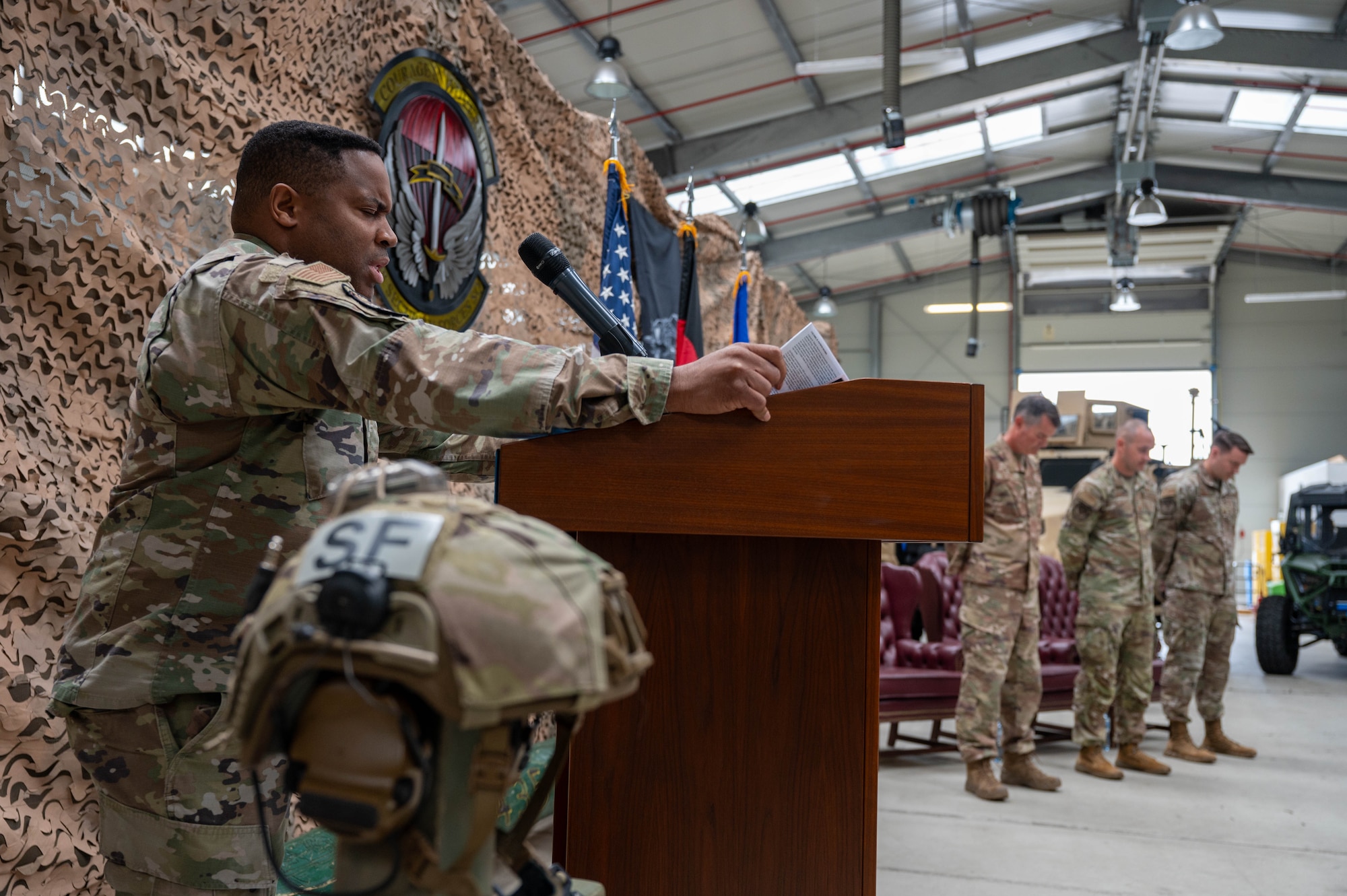 A chaplain bows his head and gives the invocation during a squadron change of command.
