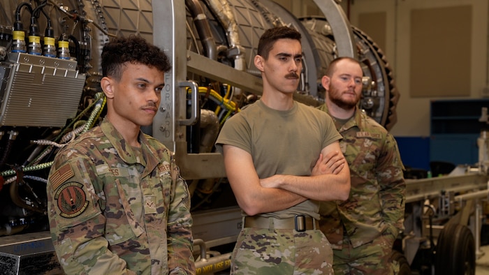 men stand and watch a video