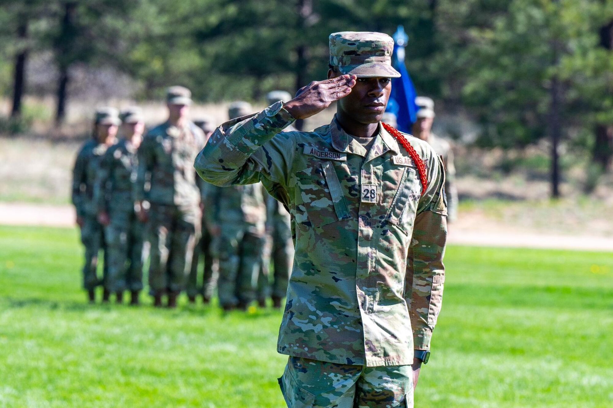 A man salutes on a parade field.