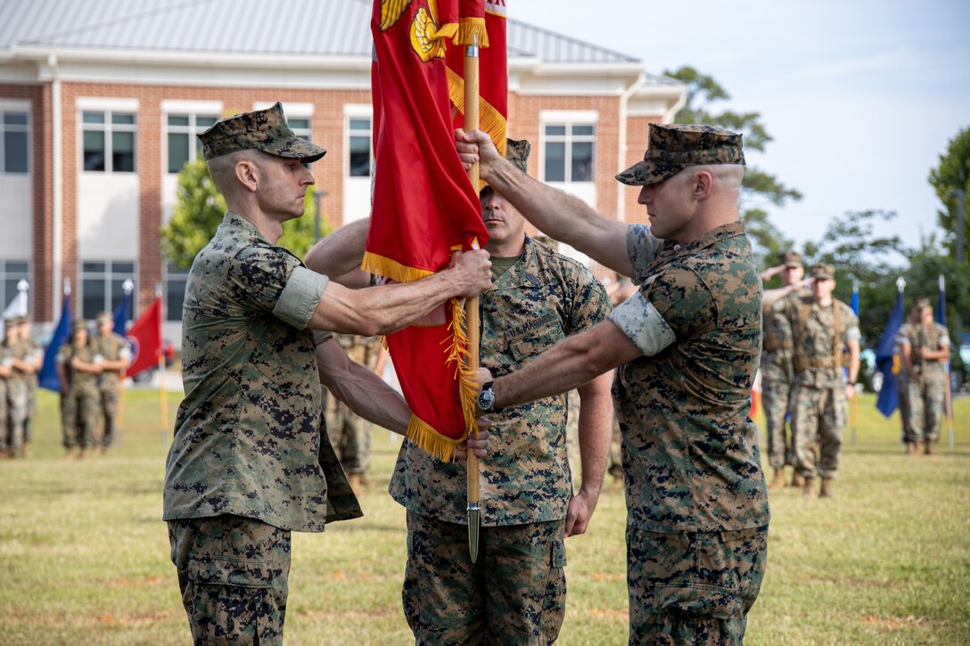 U.S. Marine Corps Lt. Col. Anthony Cesaro, right, a native of Illinois and outgoing Marine Wing Headquarters Squadron (MWHS) 2, passes the organizational colors to Lt. Col. Michael Souza, a native of Connecticut and oncoming commanding officer of MWHS-2 during a change of command ceremony at Marine Corps Air Station Cherry Point, North Carolina, June 13, 2024. The ceremony represented a transfer of responsibility, authority, and accountability from Cesaro to Souza (U.S. Marine Corps photo by Staff Sgt. Theodore Bergan)
