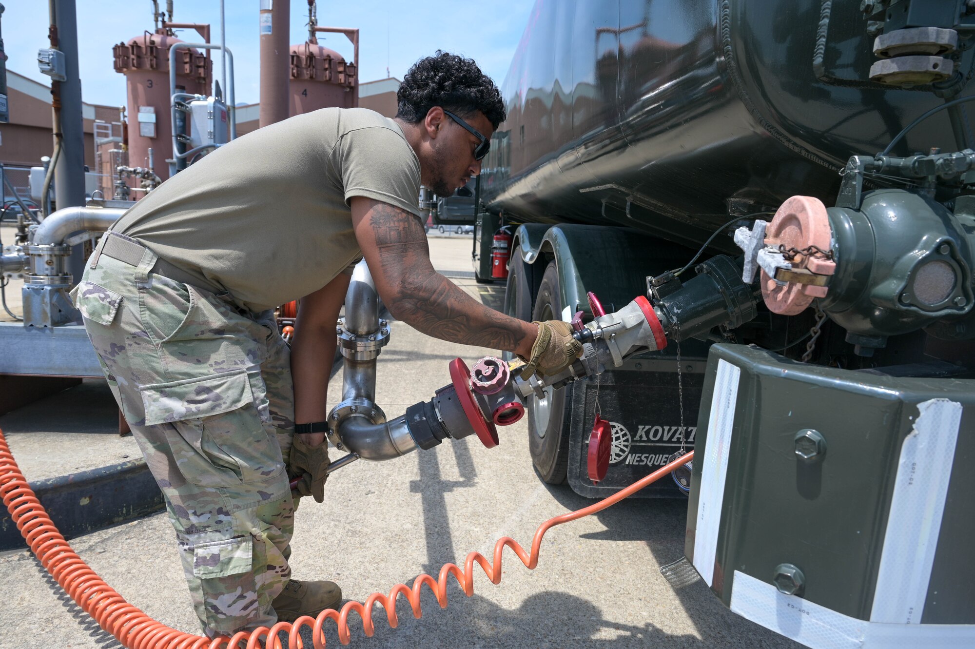 Airman attaches piece to fuel truck.