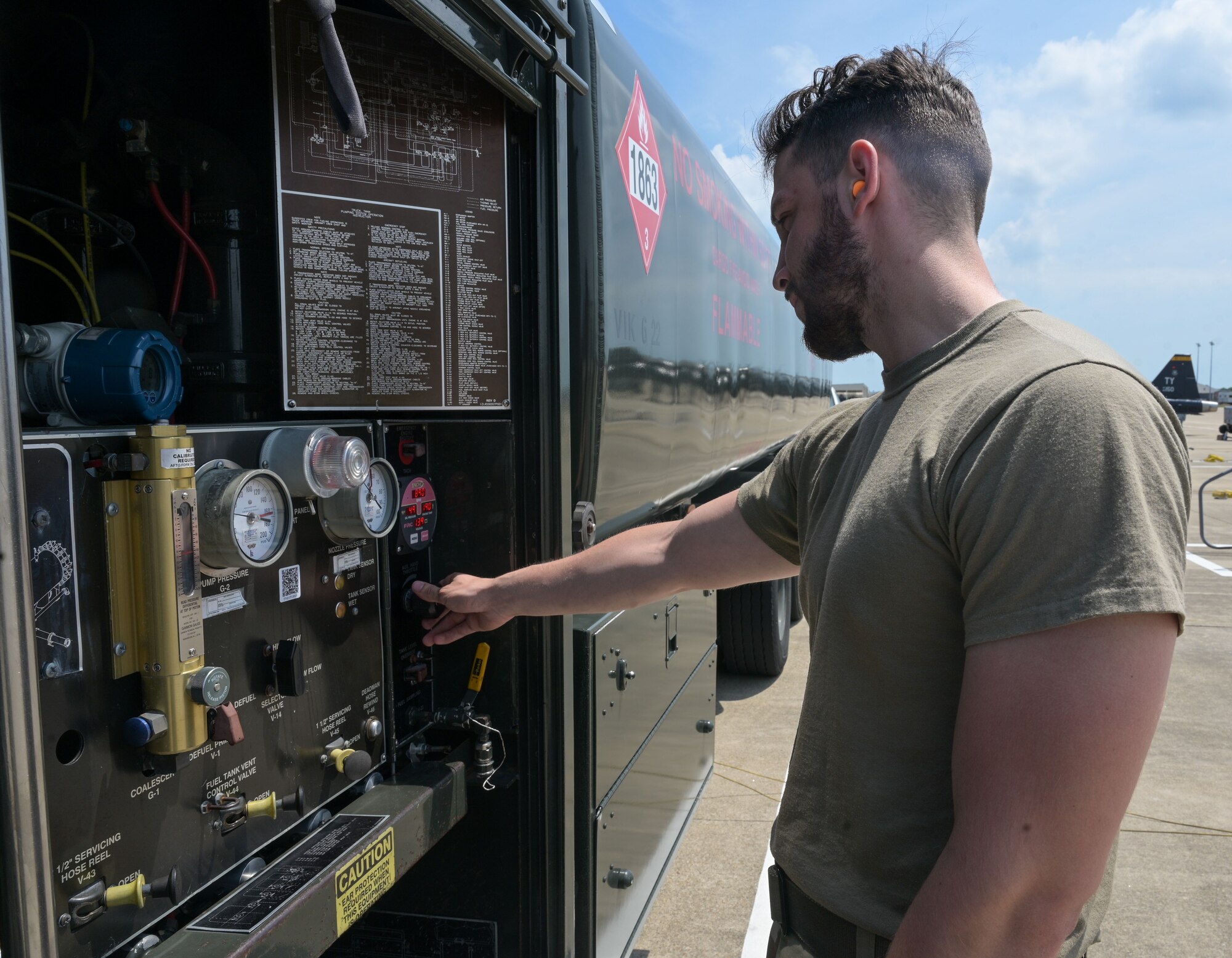Airman presses a button on fuel truck.