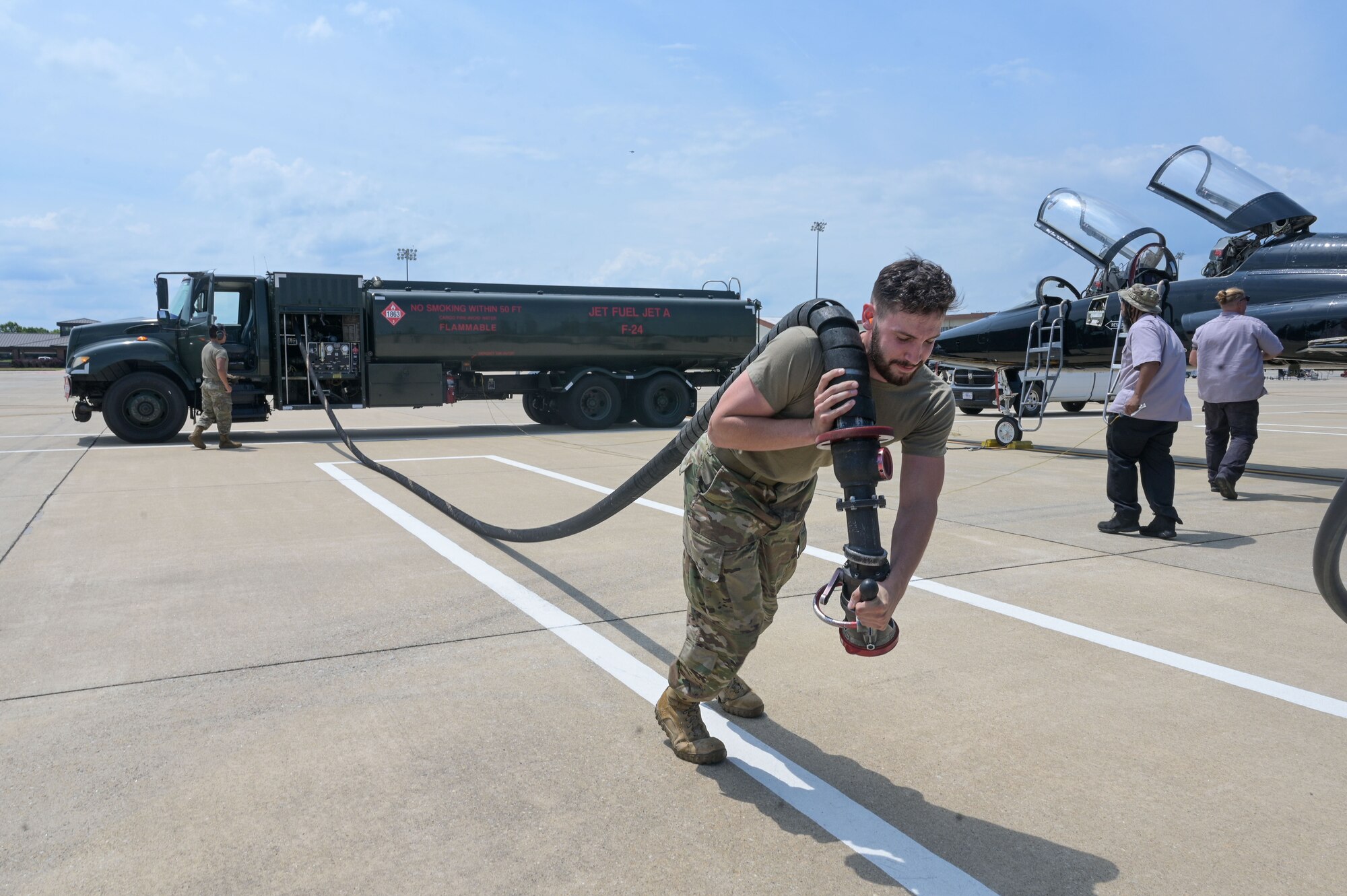 Airman pulling fuel hose.