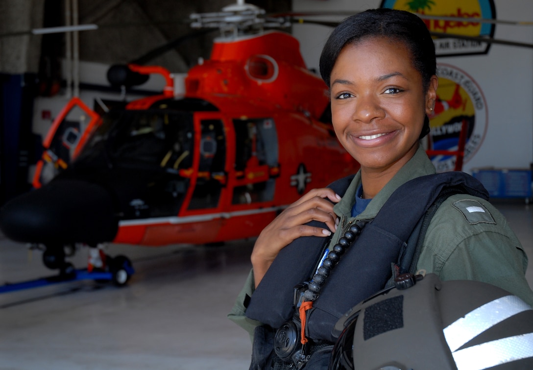 Lt. j.g. Lashanda Holmes stands in front of an MH-65 Dolphin helicopter at Air Station Los Angeles, Aug. 17, 2010.  Holmes, from Fayetteville, N.C., is the first female African-American helicopter pilot in the Coast Guard