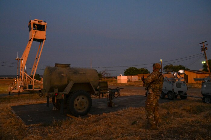 U.S. Air Force Tech. Sgt. Zachary Boone, 9th Security Forces Squadron flight chief, communicates with Airman 1st Class Kathryn Anderson, 9th Aircraft Maintenance Squadron crew chief, holding position in the sky watch tower via radio during Exercise READY DRAGON at Beale Air Force Base, California, June 3, 2024.