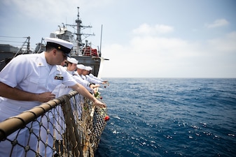 Sailors aboard the Arleigh Burke-class guided missile destroyer USS Fitzgerald (DDG 62) commit seven roses to sea to commemorate the seven-year anniversary of the June 17, 2017 collision at sea that killed seven Sailors aboard the ship.